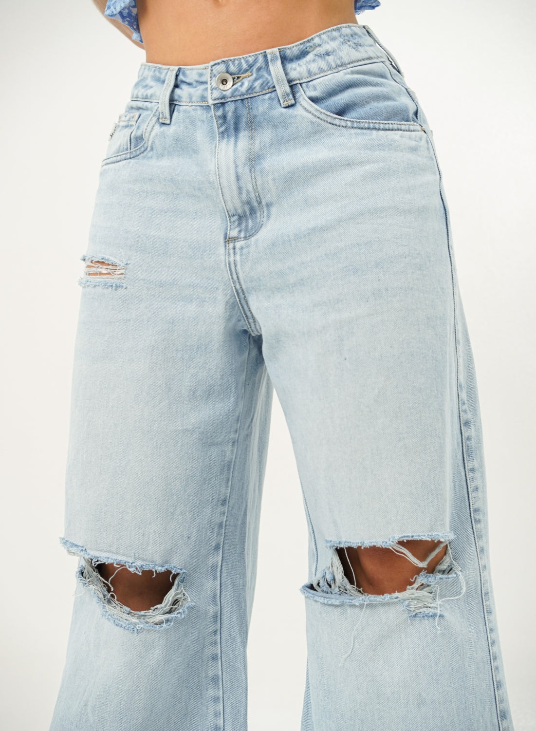 Woman wearing ripped light blue denim alien jeans