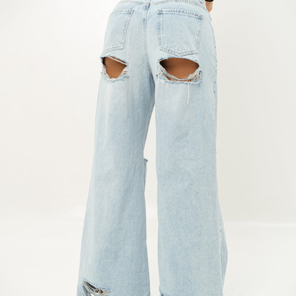 
                      
                        Woman wearing a light blue lace top and ripped denim jeans on a white background
                      
                    